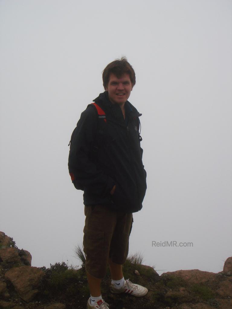 Me standing by a ledge with a wall of fog behind