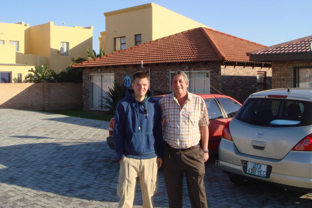 With Marius, the complex caretaker. Photo with car and some of the student village homes in the background.