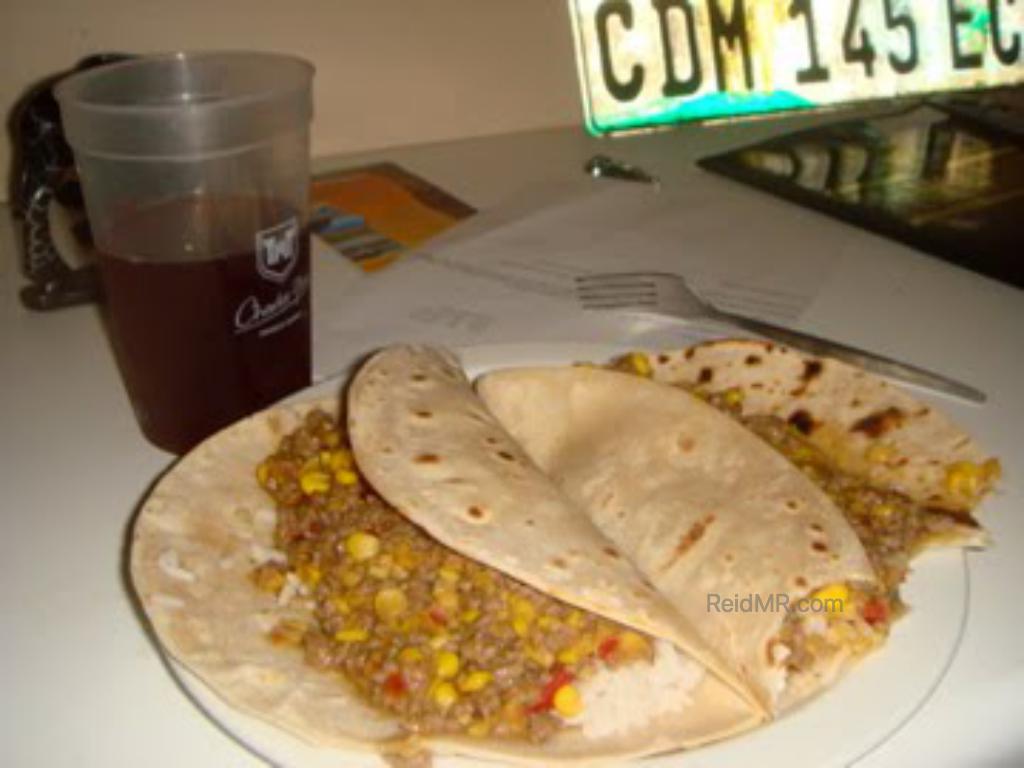 A meal, taco like, with some filling and rice.