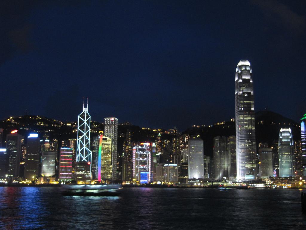 City Central, the photo of the buildings at night, with water in the foreground. 