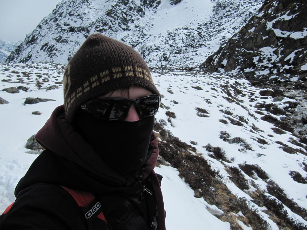 Hiking with snow on ground, me in hat, glasses and bundled up. 