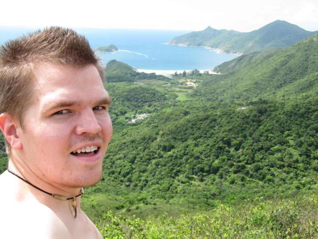 At the top of a hill, over looking the green scenery, ocean and mountains. 