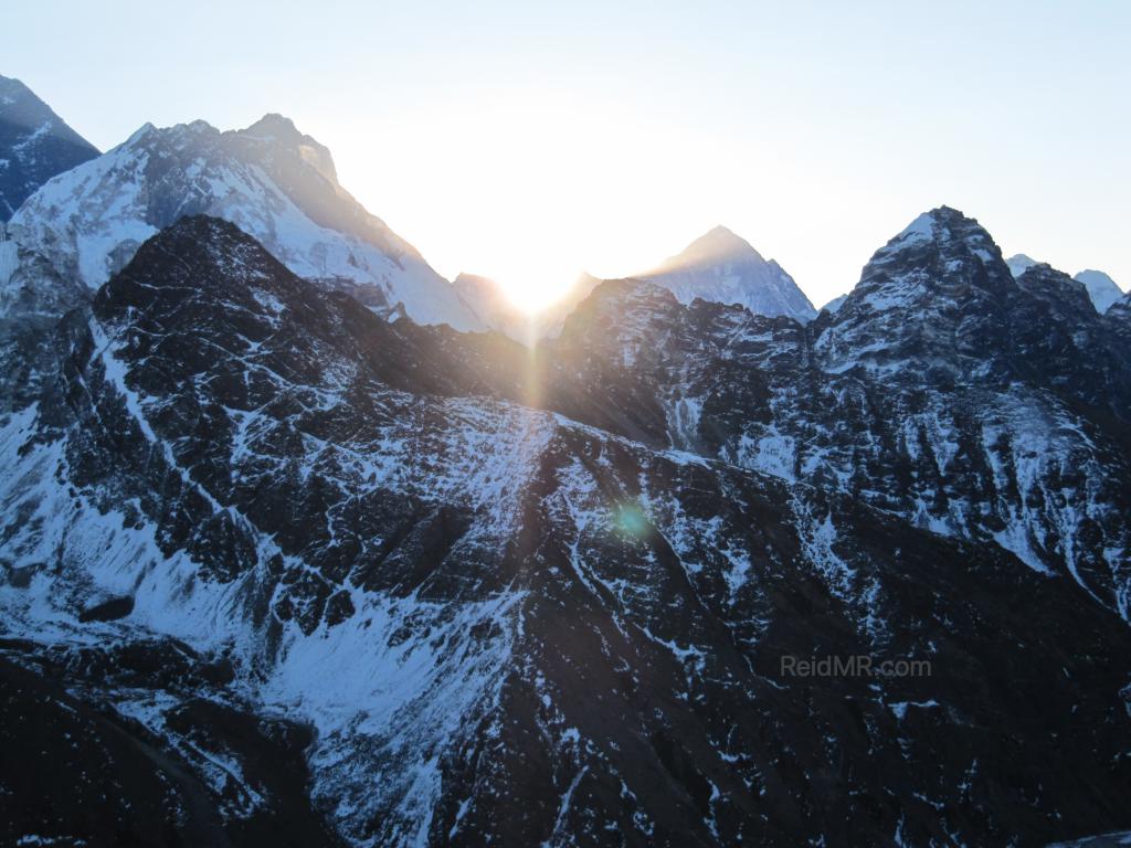 Sun coming up through the mountains, Everest is on the left