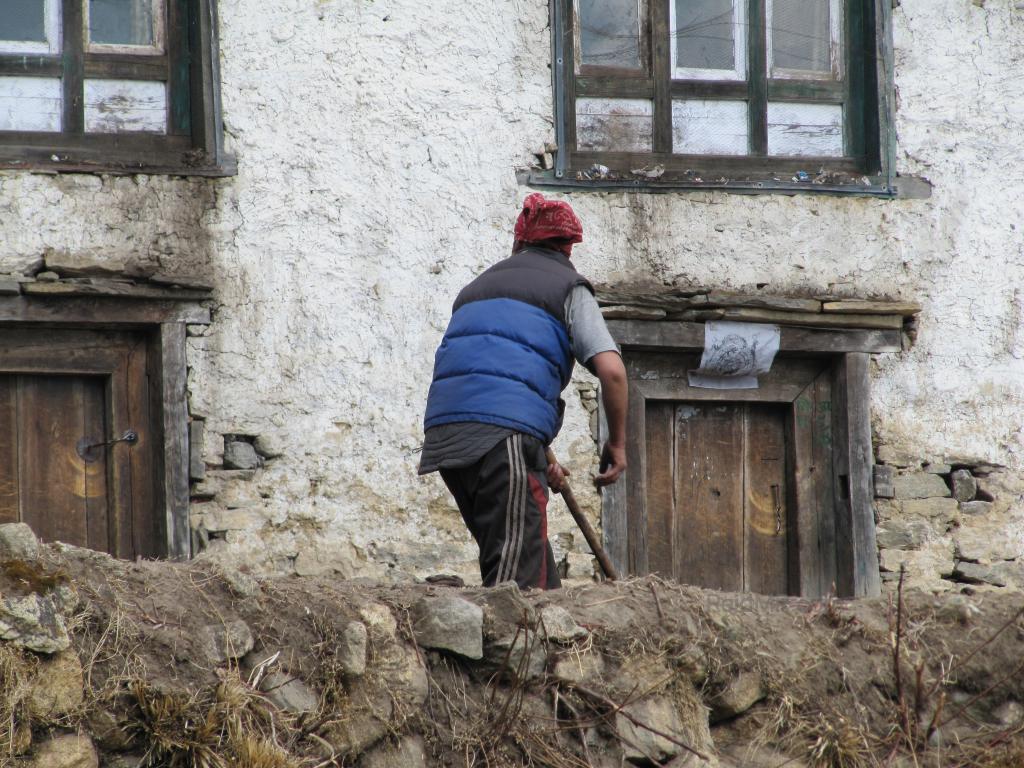 A women working up near Everest in her garden right in front of here house