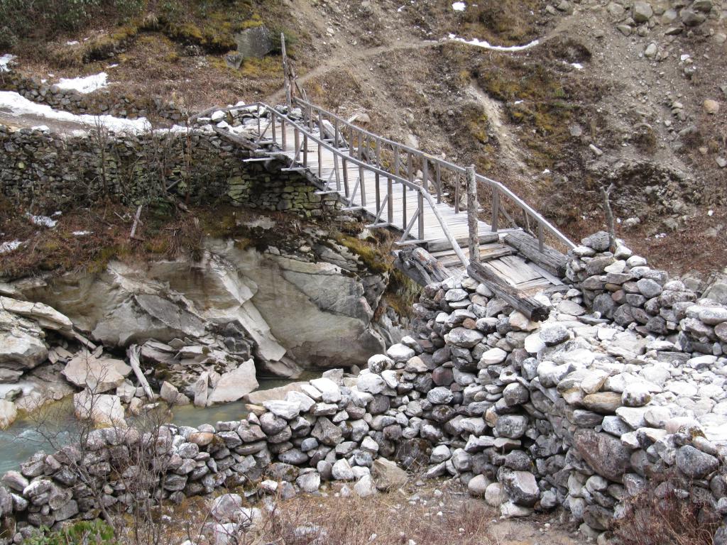 A wooden bridge going over a river