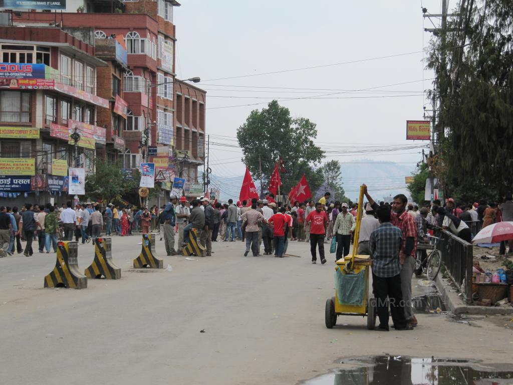 A protest, bandh, on the streets of Kathmandu. People and barricades abound. 