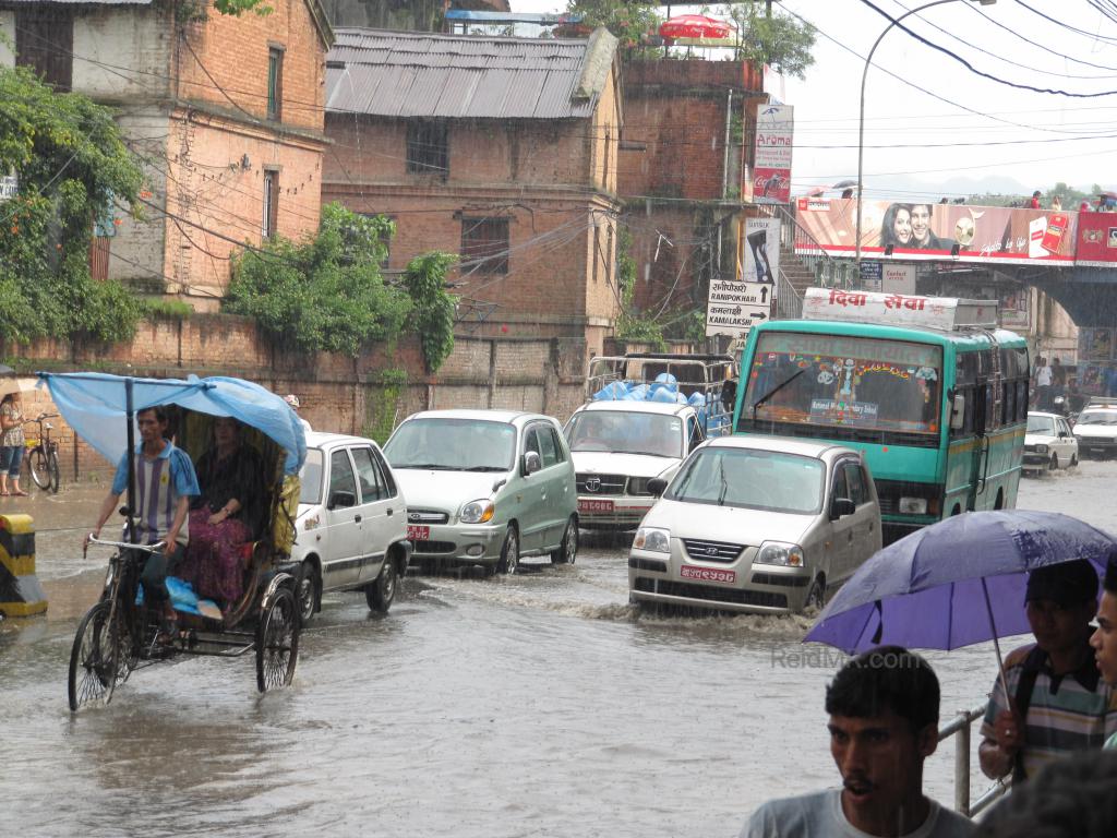 Flooded road in Kathmandu with traffic driving through