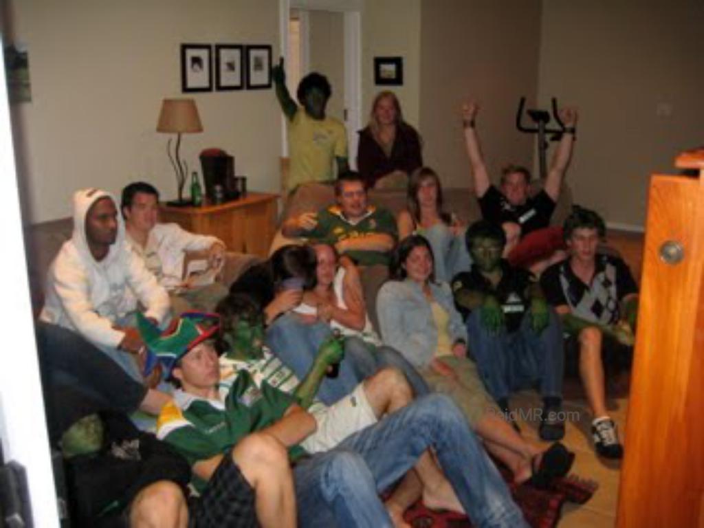 Watching the rugby game at Sean's house. Group photo of about 15 people sitting together.