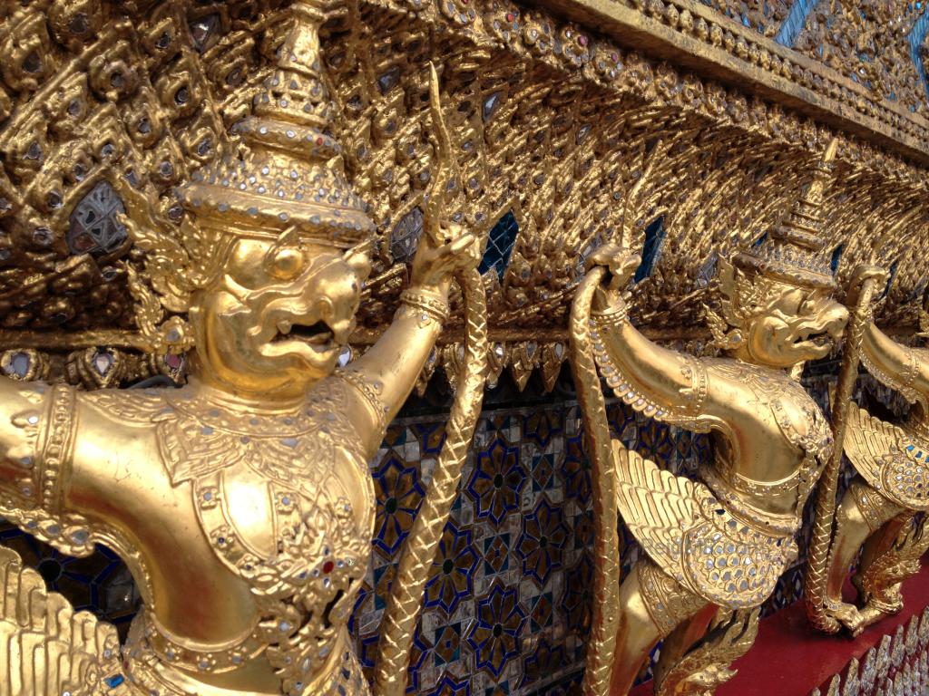 More statutes at the Temple of the Emerald Buddha, they look like they are holding up a structure and are very pained