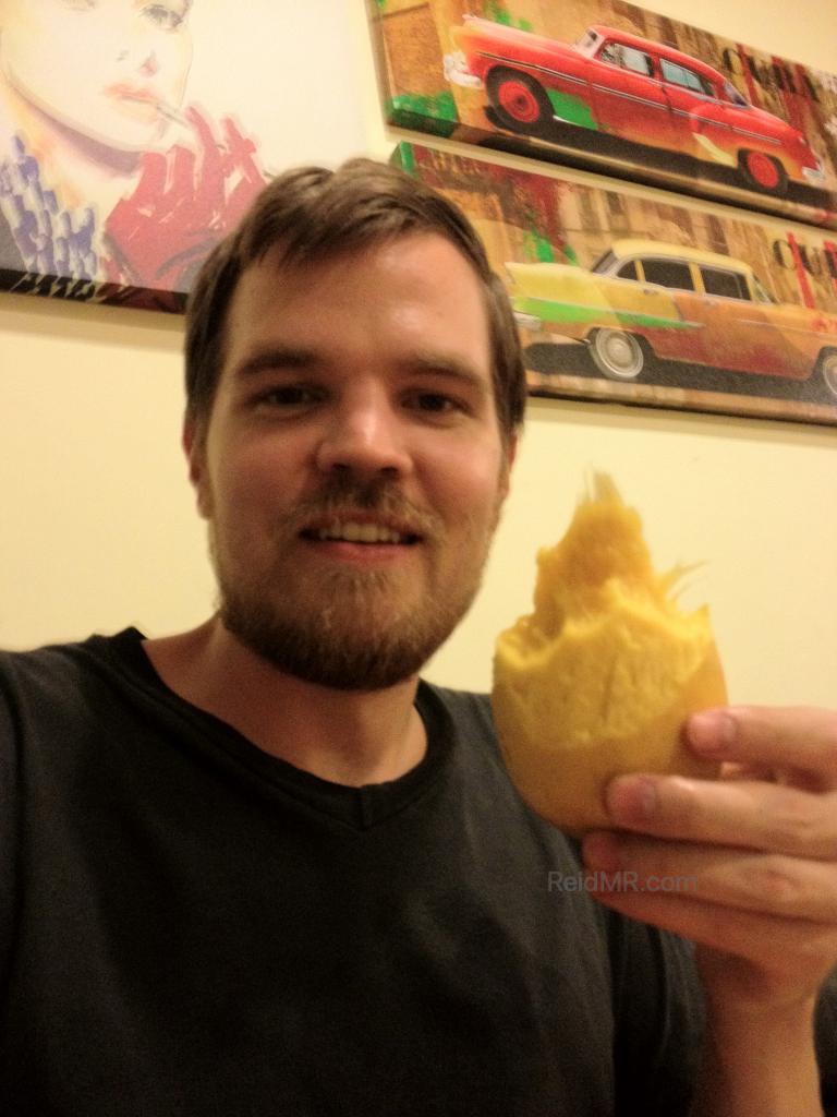 Enjoying a mango in the hostel with scruffy facial hair