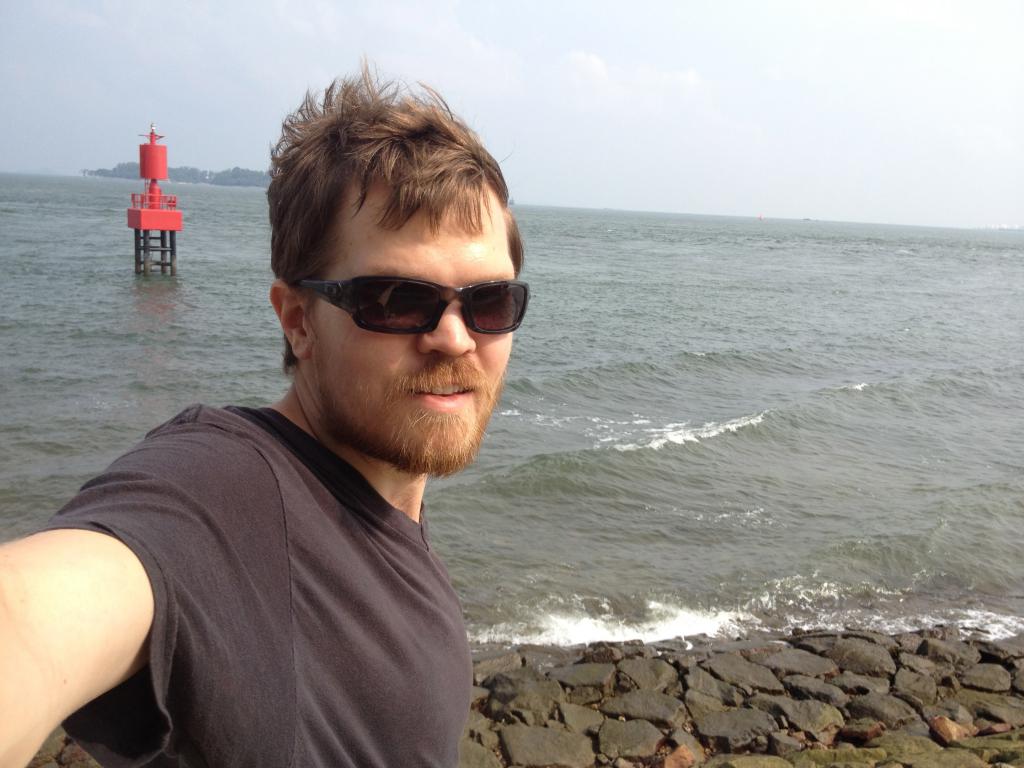 Me standing with the ocean and rocks in the background. The real southernmost point. 