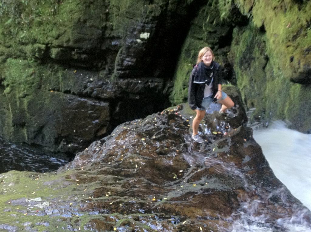 Laura smiling at the edge of a waterfall.