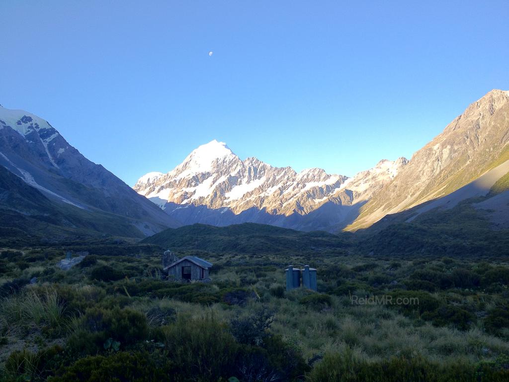 Mountains with a rest area and outdoor restroom in the middle.