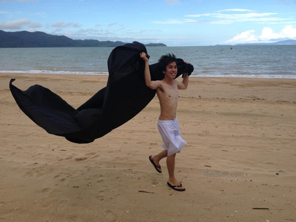 Ben playing on the beach with a sheet.